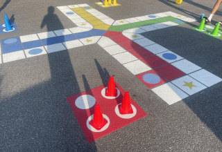 Bordspel met gekleurde kegels en dobbelsteen op de grond, genomen bij Løkken Klit Camping in Denemarken.
