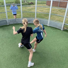 Zwei Mädchen spielen Ball in einer runden Arena bei Løkken Klit Camping in Nordjütland, Dänemark.
