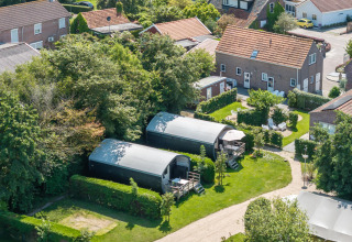 Luftfoto af 7Huizen aan Zee feriepark i Zeeland, Holland, med grønne omgivelser og små hytter.