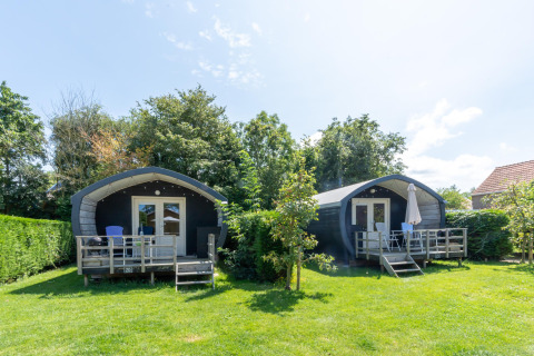 Dos acogedoras cabañas de vacaciones con terraza y muebles de jardín en 7Huizen aan Zee, Zeeland.