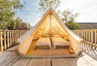 Glamping-telt med to enkeltsenge på træterrasse ved 7Huizen aan Zee, en feriepark i Zeeland, Nederlandene.