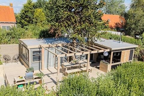 Maison de vacances moderne avec terrasse en bois et mobilier de jardin à 7Huizen aan Zee, Zélande, Pays-Bas.