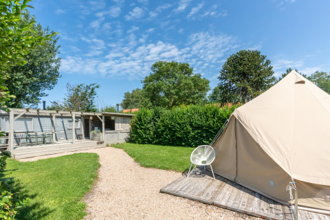 Vue extérieure au parc de vacances 7Huizen aan Zee à Zeeland, Pays-Bas, avec tente et coin salon.