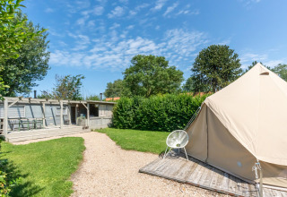 Vista esterna al villaggio turistico 7Huizen aan Zee in Zelanda, Paesi Bassi, con tenda e area giardino.