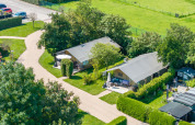 Vista aerea di due alloggi vacanza immersi nel verde a 7Huizen aan Zee, parco vacanze in Zelanda, Paesi Bassi.