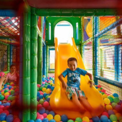 Niños jugando en una piscina de bolas colorida con tobogán en Camping Aminess Maravea, Istria, Croacia.