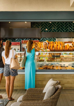 Tres mujeres esperan en una panadería con pan fresco en Camping Aminess Maravea, Istria, Croacia.