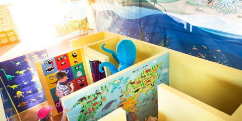 Bambini giocano in un’area giochi interna colorata con murales e polpo blu in Istria, Croazia.