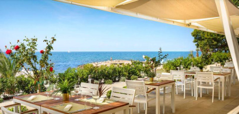 Außenrestaurant im Camping Aminess Maravea in Istrien, Kroatien, mit Meerblick und sonnigem Wetter.