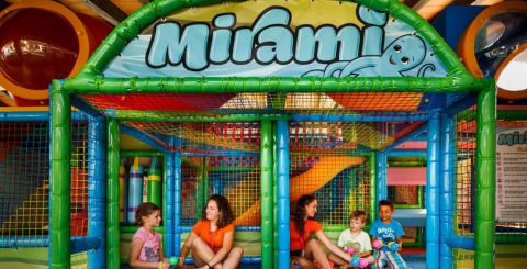 Bambini e adulti si divertono insieme nell'area giochi coperta e colorata del Camping Aminess Maravea, Istria, Croazia.
