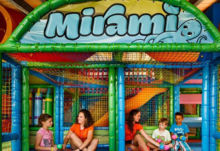 Bambini e adulti si divertono insieme nell'area giochi coperta e colorata del Camping Aminess Maravea, Istria, Croazia.