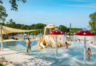 Enfants jouant dans une aire de jeux aquatique avec fontaines champignons au Camping Aminess Maravea, Croatie.