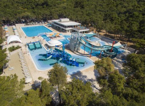Vista aérea de Camping Cikat con piscinas, toboganes acuáticos y bosque alrededor en Croacia.