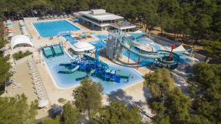 Vista aérea de Camping Cikat con piscinas, toboganes acuáticos y bosque alrededor en Croacia.
