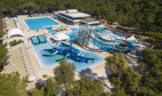 Vista aérea de Camping Cikat con piscinas, toboganes acuáticos y bosque alrededor en Croacia.