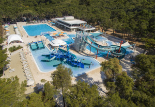 Vista aérea de Camping Cikat con piscinas, toboganes acuáticos y bosque alrededor en Croacia.