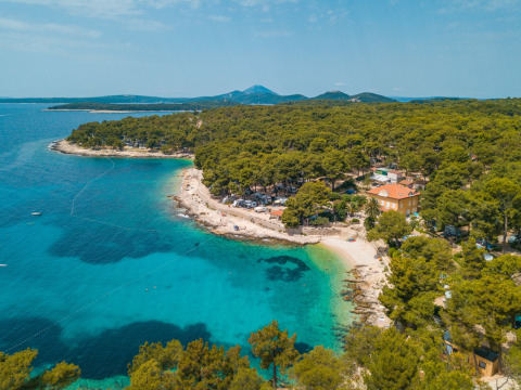 Aerial view of Camping Cikat in Primorje-Gorski Kotar, Croatia, with turquoise bay, forest and sandy beach.