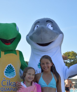 Dos niños posan con mascotas de rana y delfín junto a la piscina en Camping Čikat, Croacia.