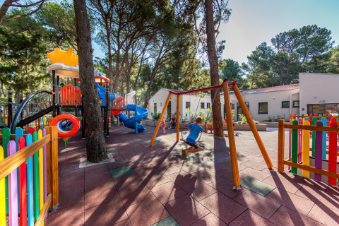 Spielplatz mit buntem Zaun, Schaukeln und Rutschen im Camping Cikat, Primorje-Gorski Kotar, Kroatien.
