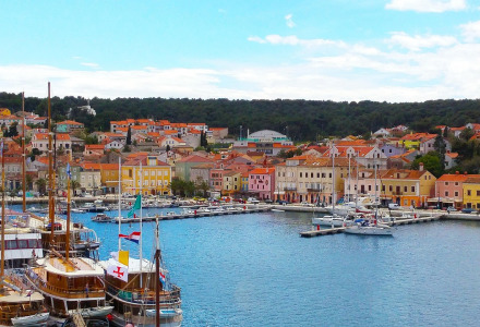 Vista del pintoresco puerto de Mali Lošinj, Croacia, con edificios coloridos y barcos atracados.