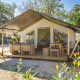 Safari telt Comfort med aircondition, udendørs opholdsområde og træmøbler på solrig campingplads.