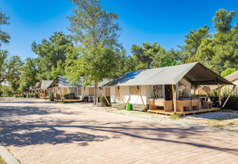 Række af komfortable safaritelte med aircondition på Camping Stella Maris, Kroatien, under blå himmel