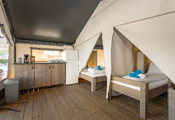 Tenda Safari Comfort al Camping Stella Maris in Croazia con due letti, pavimento in legno e angolo cottura.