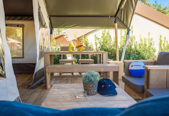 Vista interior de la Safari Tent Comfort en Camping Stella Maris, Croacia, con muebles de madera y decoración.