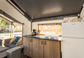 Interno della Safari Tent Comfort al Camping Stella Maris in Croazia, cucina moderna e area salotto accogliente.