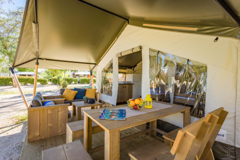 Buitenruimte bij de Safari Tent Comfort op Camping Stella Maris in Kroatië met houten meubels en overkapping.