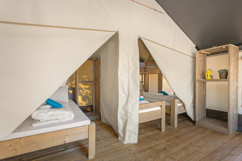 Interno di Safari Tent Comfort al Camping Stella Maris in Croazia con letti in legno e pareti in tela.