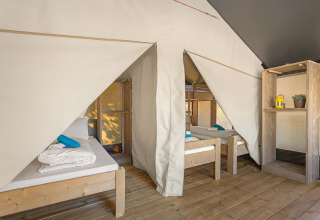 Interior de la tienda Safari Tent Comfort en Camping Stella Maris, Croacia, con camas de madera y lonas.