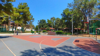 Cancha deportiva al aire libre en Camping Stella Maris, un parque vacacional en Istria, Croacia, rodeado de árboles.