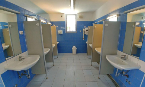 Gemeenschappelijke badkamer met blauwe tegels en privédouches bij Camping Stella Maris, Istrië, Kroatië.