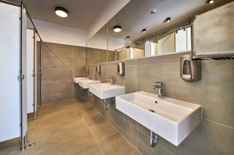 Modern restroom at Camping Stella Maris in Istria, Croatia, with tiled walls, mirrors, and white sinks.