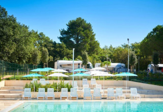 Swimming pool with sun loungers and umbrellas at Camping Stella Maris holiday park in Istria, Croatia.