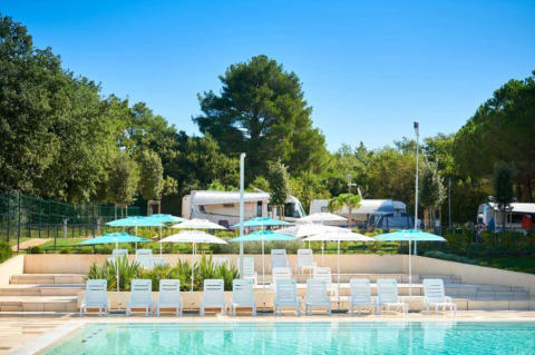 Swimming pool with sun loungers and umbrellas at Camping Stella Maris holiday park in Istria, Croatia.