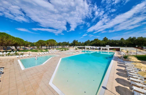 Ampia piscina all'aperto con lettini presso Camping Stella Maris, parco vacanze in Istria, Croazia.