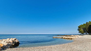 Hermosa vista de la playa de guijarros en Camping Stella Maris en Istria, Croacia, bajo un cielo azul claro.