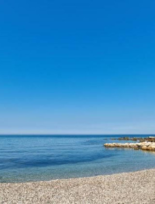 Hermosa vista de la playa de guijarros en Camping Stella Maris en Istria, Croacia, bajo un cielo azul claro.