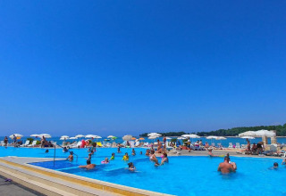 Feriepark Camping Stella Maris i Istrien, Kroatien, med gæster i swimmingpoolen og parasoller ved havet.