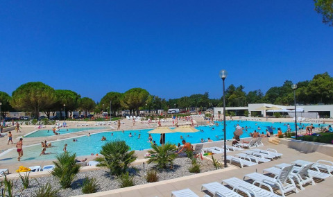 Outdoor pool area at Camping Stella Maris holiday park in Istria, Croatia, filled with people on a sunny day.