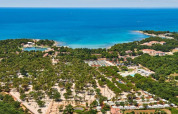 Vista aerea del Camping Stella Maris in Istria, Croazia, circondato da verde, edifici e mare blu.