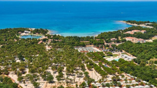 Luchtfoto van vakantiepark Camping Stella Maris in Istrië, Kroatië, omringd door bomen, gebouwen en zee.
