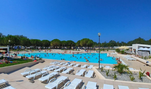Outdoor swimming pool with sun loungers and vacationers at Camping Stella Maris holiday park in Istria, Croatia.