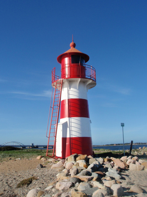 Faro rojo y blanco en Toftum Bjerge Camping, parque vacacional en la Región Central de Dinamarca, día soleado.