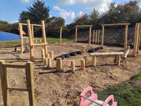 Buitenspeelplaats bij Toftum Bjerge Camping in Denemarken met houten balanceertoestellen.