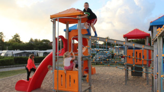 Niños jugando en el parque infantil de Toftum Bjerge Camping, un complejo vacacional en Dinamarca central.