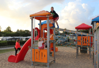 Niños jugando en el parque infantil de Toftum Bjerge Camping, un complejo vacacional en Dinamarca central.