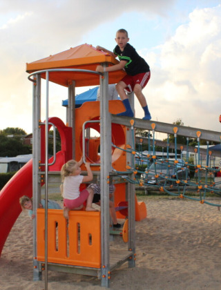 Niños jugando en el parque infantil de Toftum Bjerge Camping, un complejo vacacional en Dinamarca central.